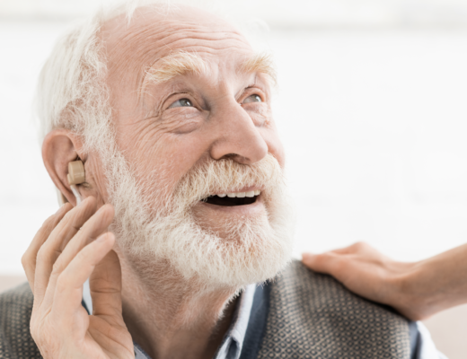 Starszy mężczyzna zakłada aparat słuchowy