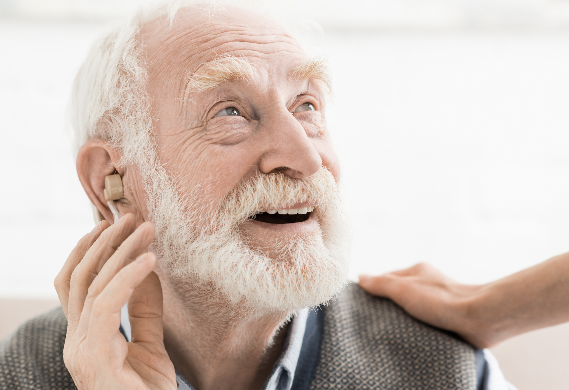 Starszy mężczyzna zakłada aparat słuchowy
