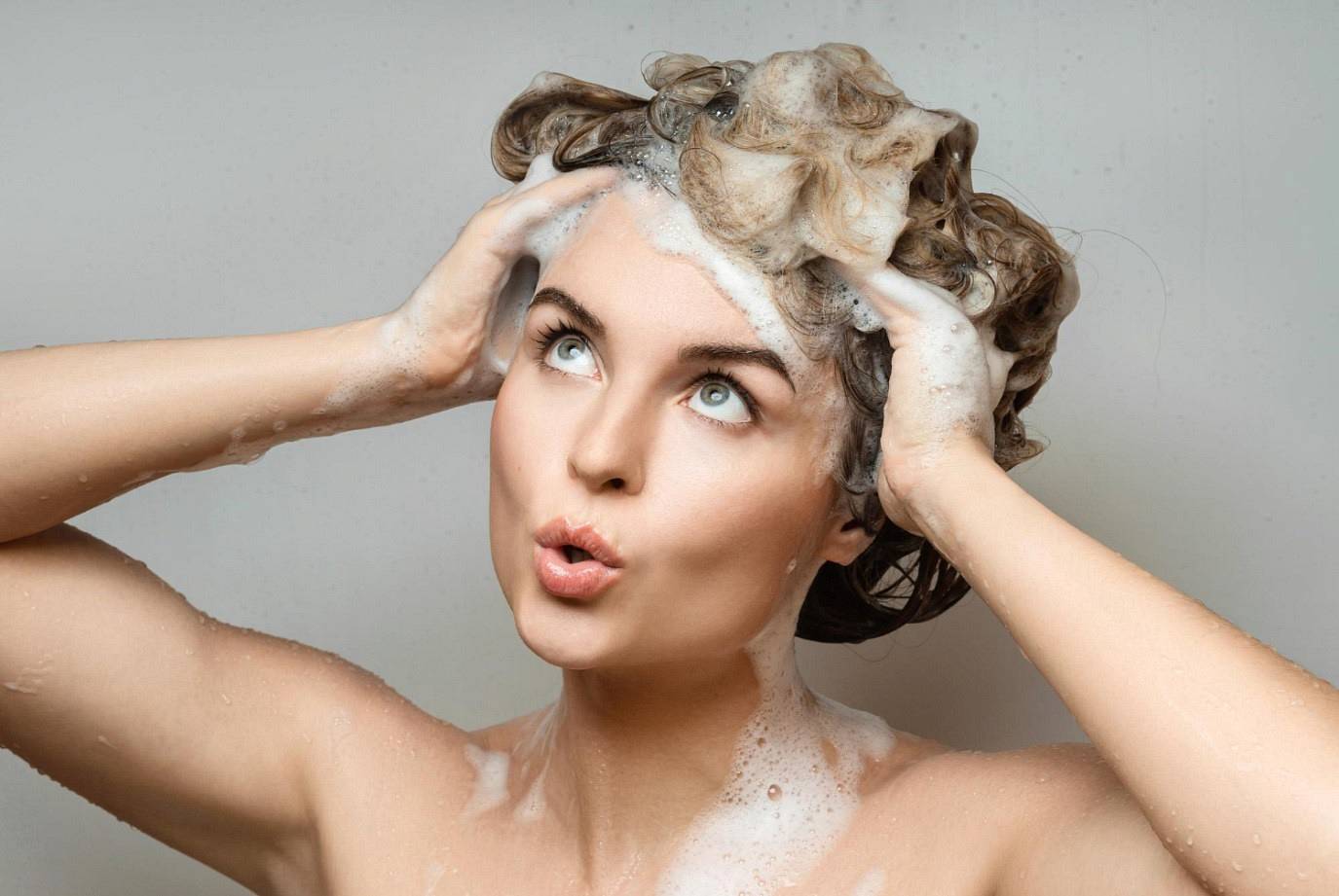 Kobieta korzysta z szamponu do włosów przetłuszczających się